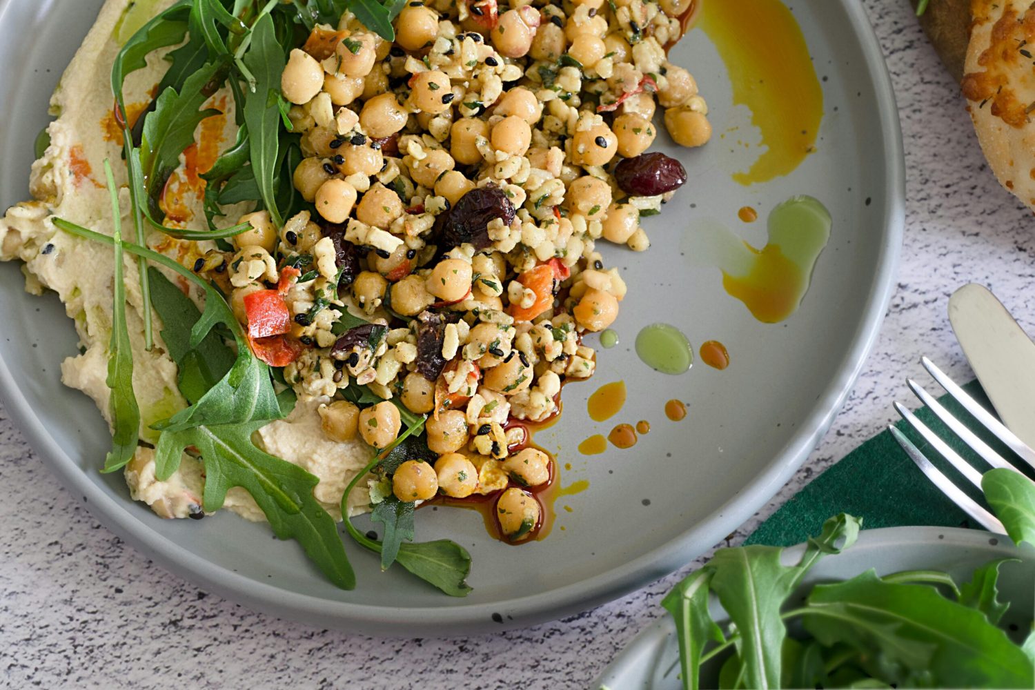 A plate of plant foods, hummus, rocket, chickpeas