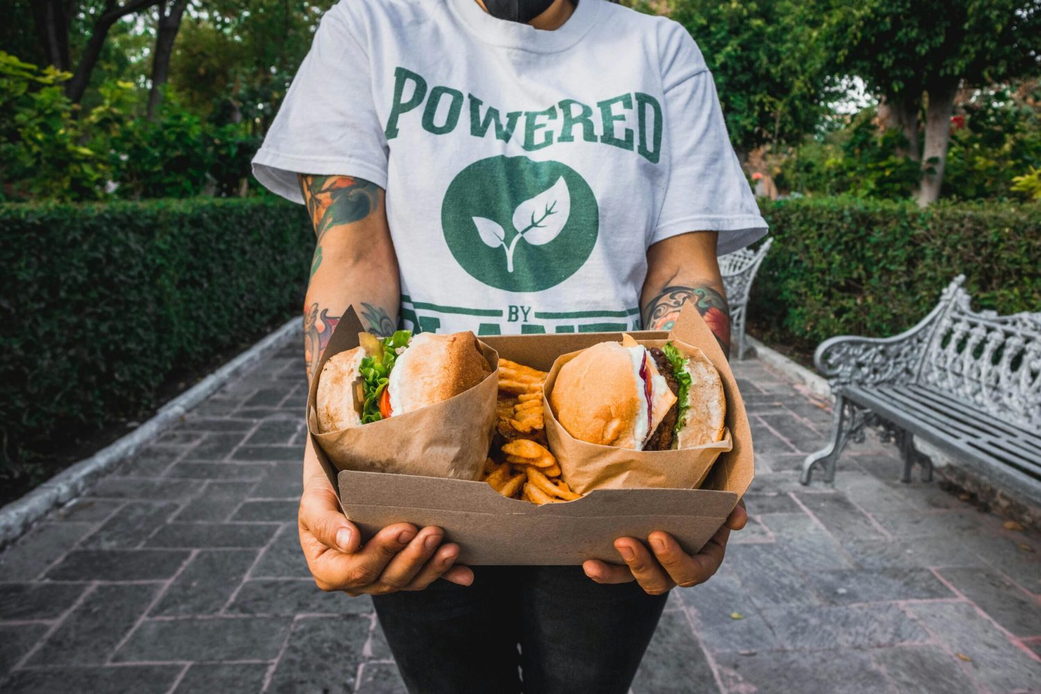 Person in a plant-powered t-shirt holding vegan burgers
