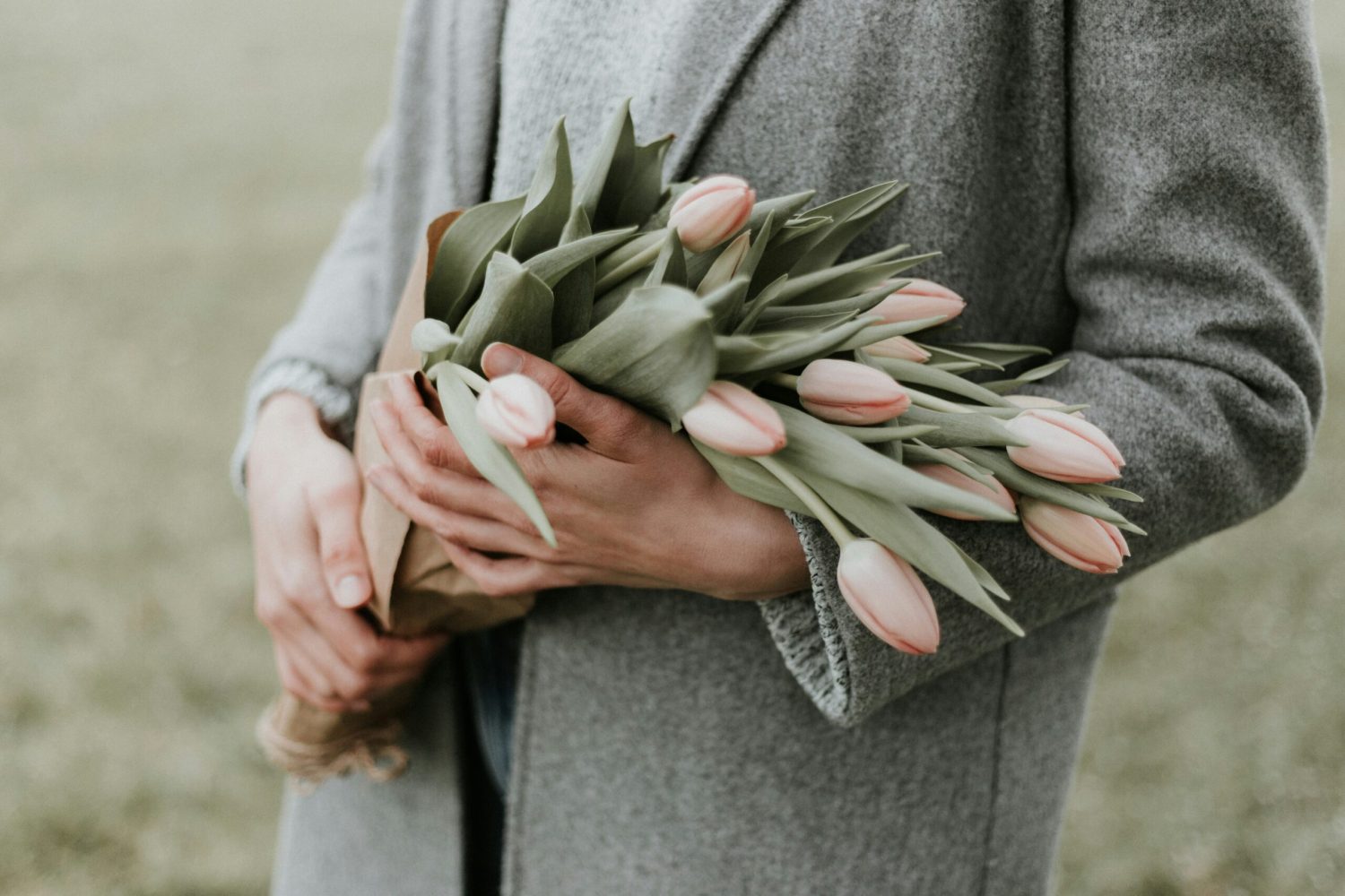 Woman holding bunch of pink tulips